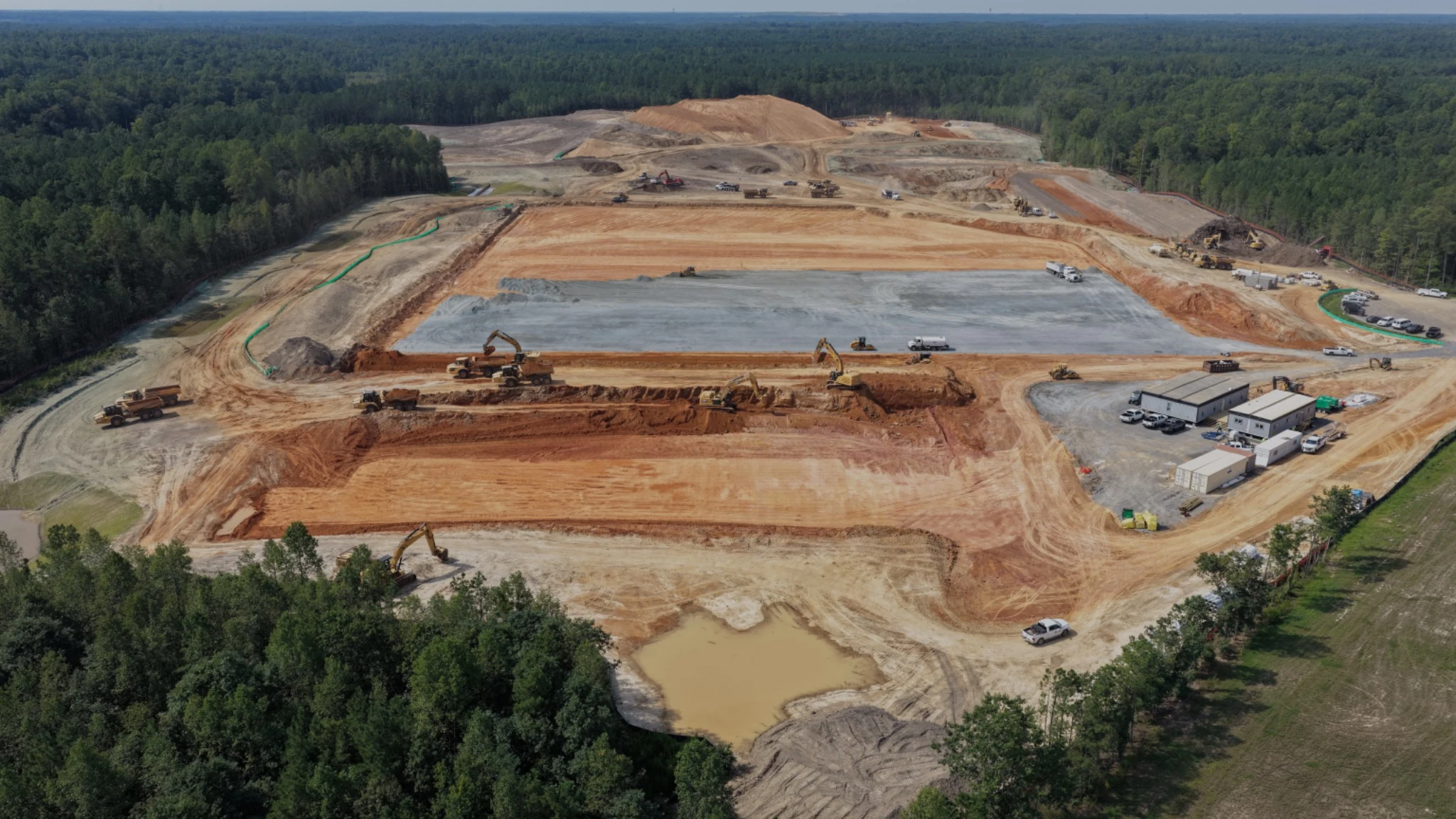 Wide view of the prepared acreage, central pad and active earthwork operations.