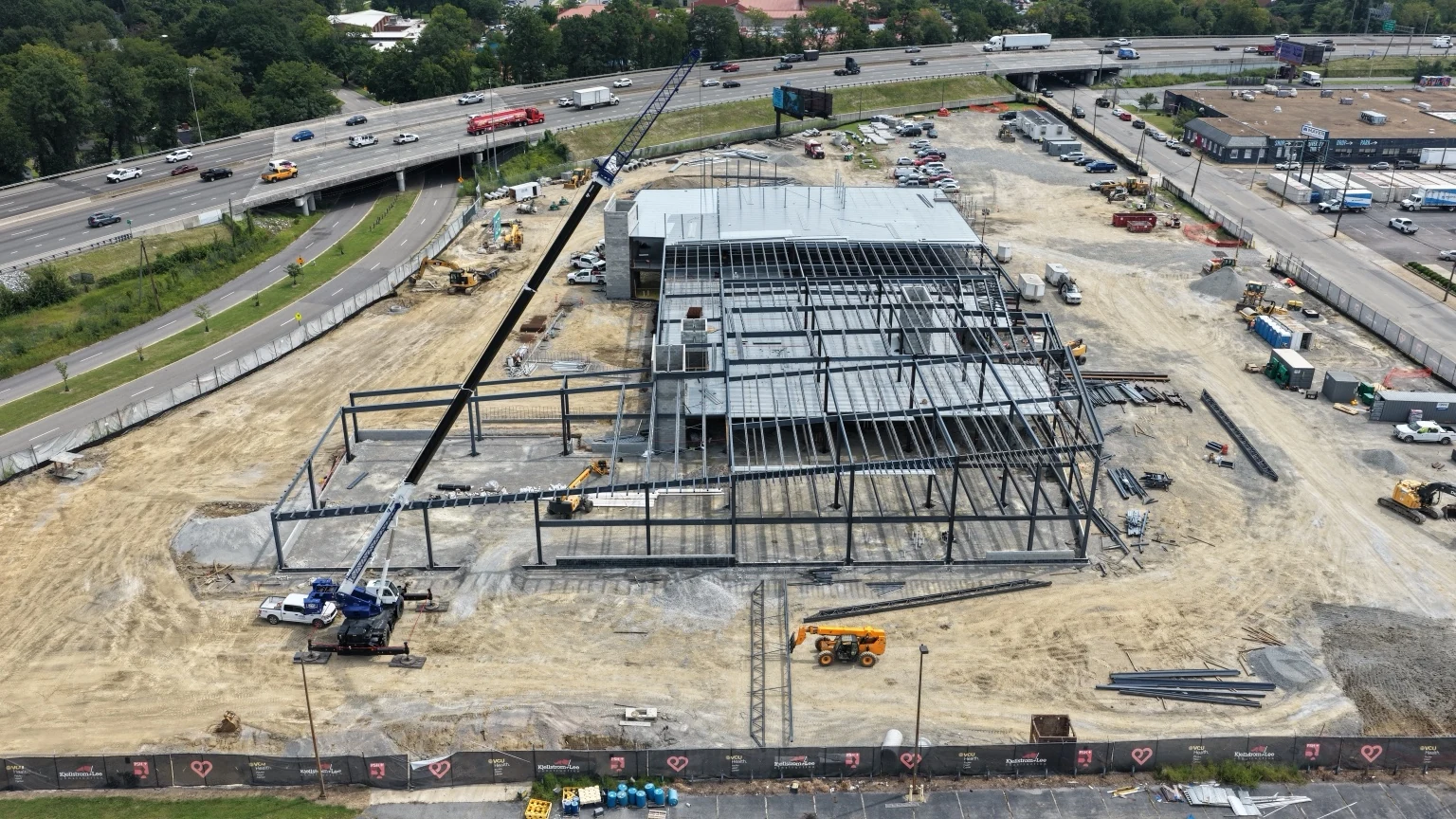 Current VCU Heart Center structural-progress view with crane operations, site circulation and interstate context.