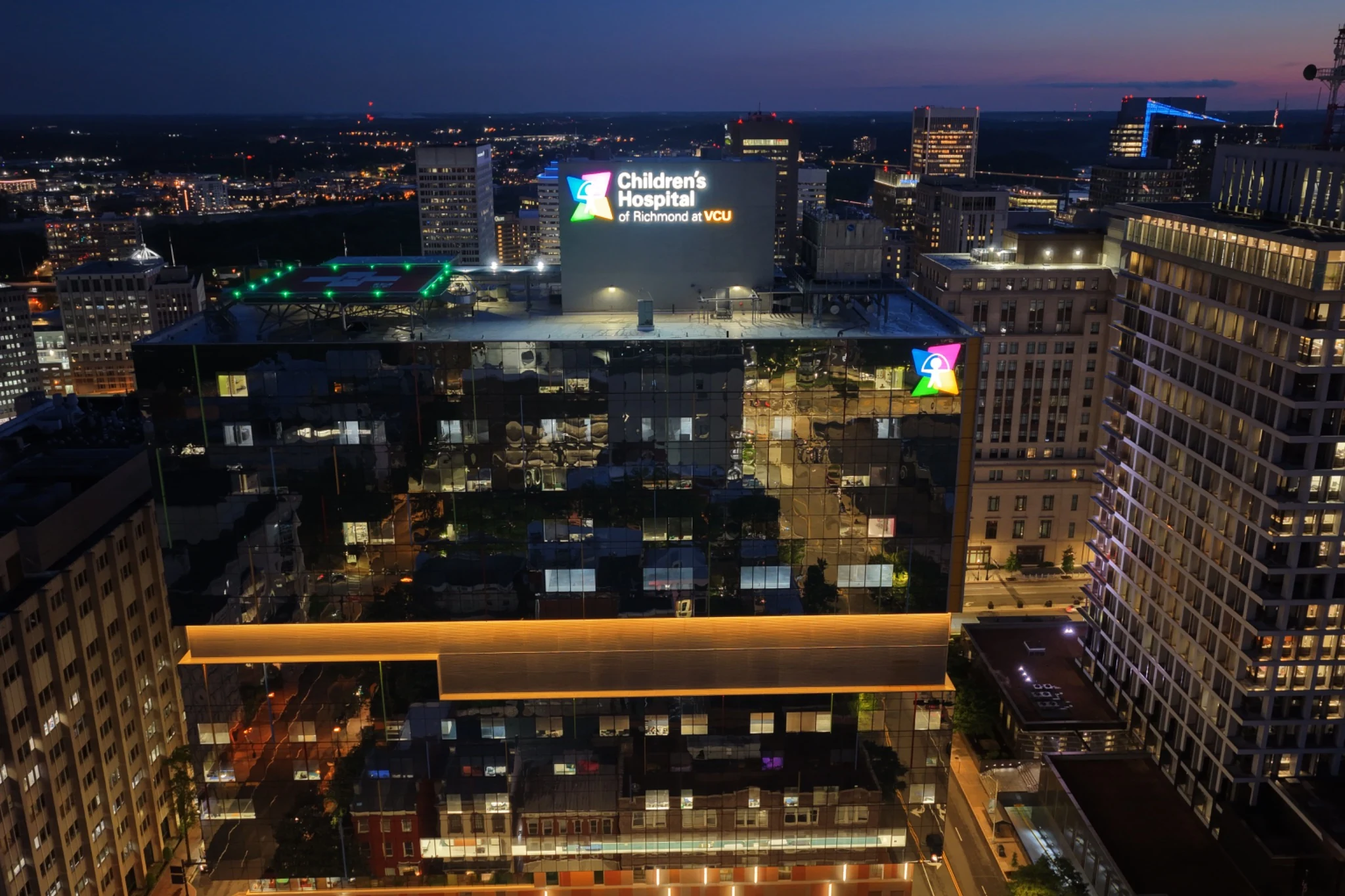 Front-facing dusk aerial of the Children’s Hospital of Richmond at VCU within the downtown skyline.