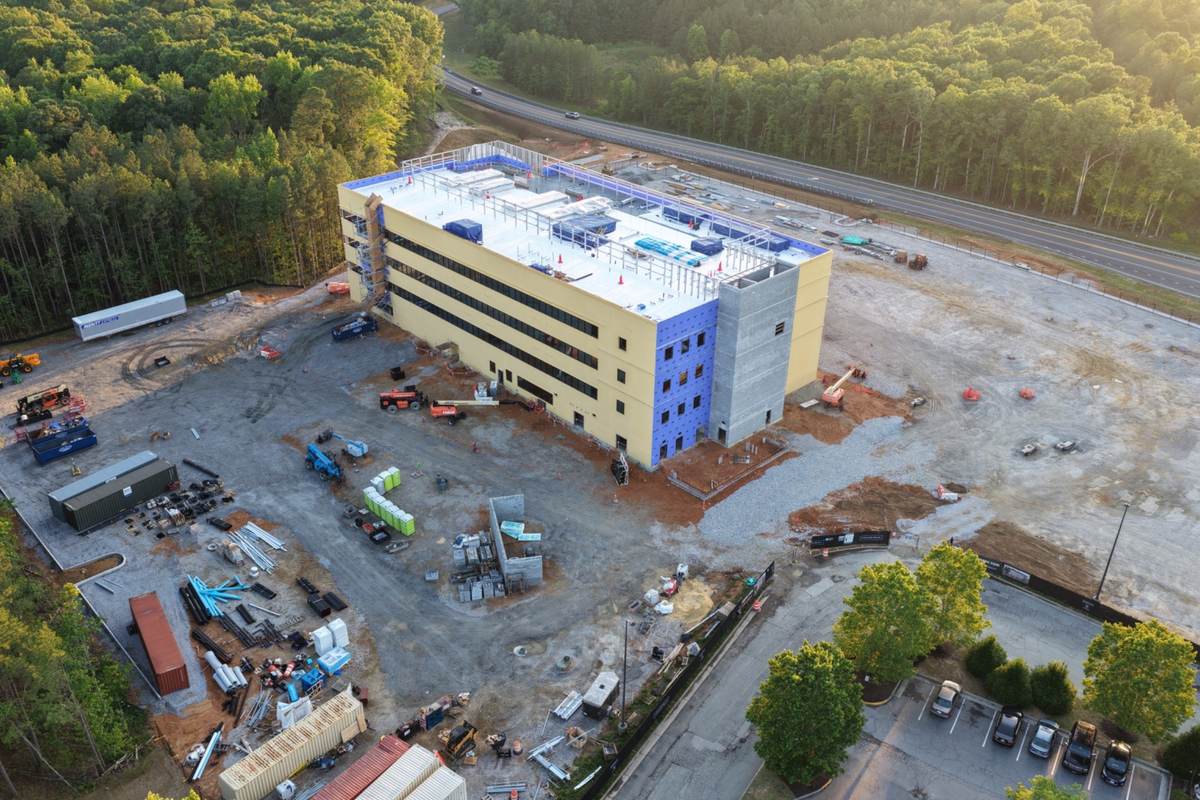 Aerial healthcare construction progress photo showing medical facility exterior work and site logistics
